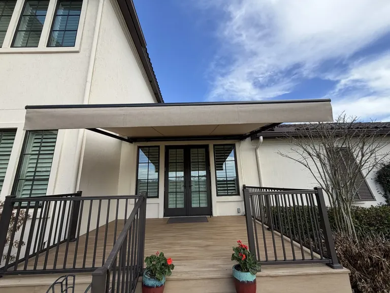 Motorized awning paired with an OpenRoller cable-guided solar screen at a Marsh Landing home in Ponte Vedra Beach, Florida