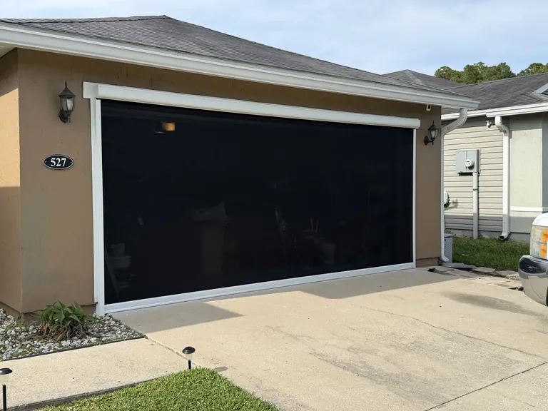 Motorized retractable screen across a two-car garage opening in Northside Jacksonville, Florida