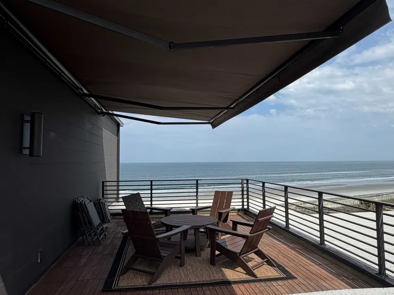 Motorized solar screen controlling sun and glare on a coastal patio in St. Augustine Beach, Florida