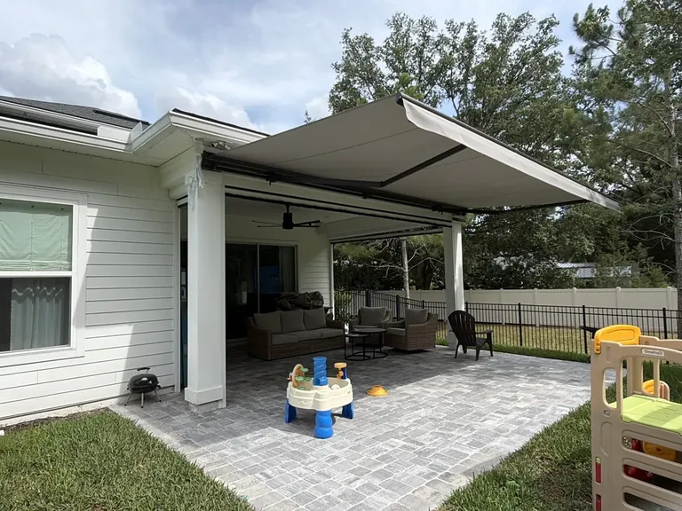 Motorized retractable awning, insect screens, and integrated LED lighting installed over a St. Johns, Florida patio