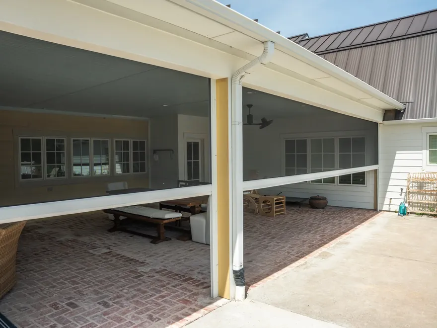 Residential patio motorized insect screens with white hardware, exterior view