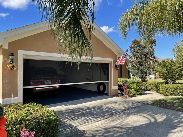 Motorized insect screen enclosing a residential garage bay