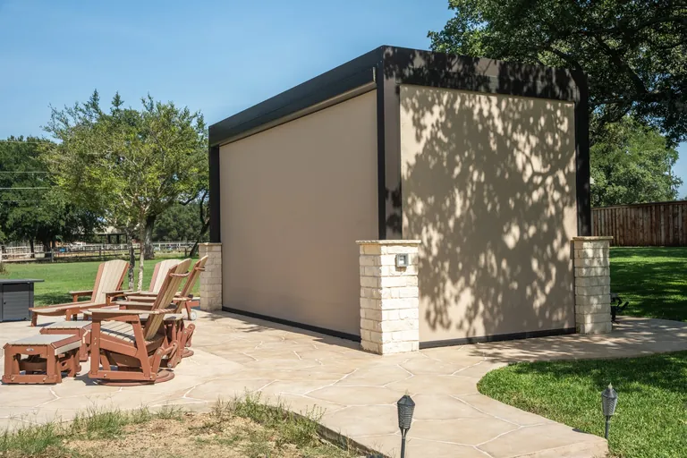 Residential motorized screens enclosing a poolside pergola for shade and insect protection